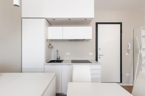 A compact kitchenette with a sink, cabinets, and a door. - San Gervasio Apartment by Wonderful Italy (Bologna)