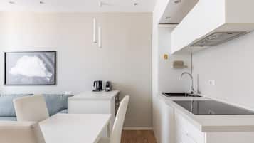 A modern kitchen with a black countertop, white cabinets, and a stainless steel sink.