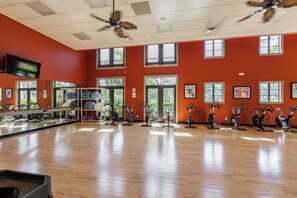 A gym with exercise bikes, a TV, and large windows. - 3bed/2.5Resort-style Paseo QUAD home w/semi-private pool. (Fort Myers)
