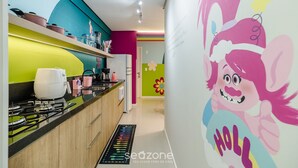 A kitchen with modern appliances, a colorful backsplash, and a festive wall mural. - 2-bedrthemed Rainbow Ap With Barbecue Obp0301 (Penha)