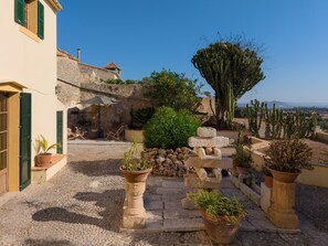 A courtyard with stone steps, potted plants, and a view of the countryside. - Son Idò by Rentallorca (Muro)