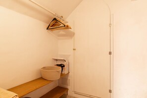 A hallway with a wooden bench, a hanging clothes rack, and a door. - Son Idò by Rentallorca (Muro)