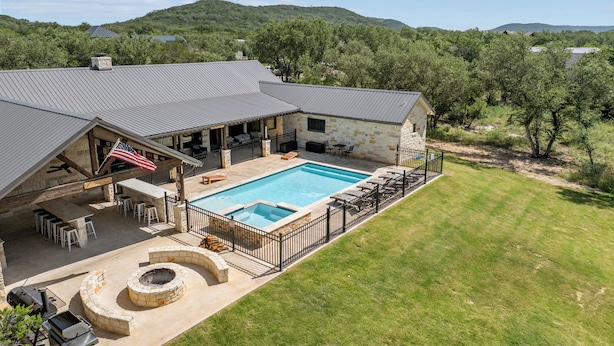 A house with a swimming pool, outdoor seating, and a barbecue area. - Hidden Creek - near Frio River - 6 bedroom - hot tub - pool - outdoor kitchen (Concan)