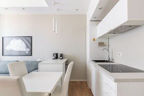 Eine moderne Küche mit Einbauherd, Spüle und Essbereich inklusive Tisch und Stühlen.