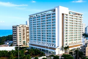 Ein modernes Hotel mit einem Fenstergitter, einer flachen Dachkonstruktion und Blick auf das Meer.
