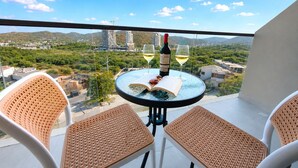 A balcony with a table, two chairs, a bottle of wine, and two wine glasses. - Reserva del Mar II Apartment - Cantamar SOHO -391A (Santa Marta)