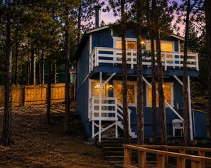 A multi-level wooden cabin with a balcony, surrounded by trees. - Big Bear Escape: Cozy Fireplace! Dine Al Fresco! (Big Bear City)