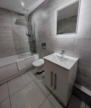 Ein modernes Badezimmer mit Badewanne, Toilette und Waschtisch.