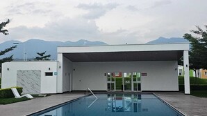 Una piscina moderna con vista chiara sulle montagne sullo sfondo.