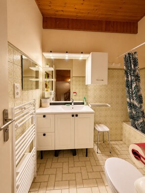 A bathroom with a white vanity, a mirror, a shower curtain with a leaf pattern, a toilet, and a radiator. - Panoramic view • Downtown and walking trails • Serves 6 (Châtel)