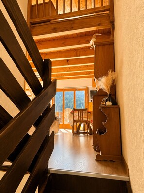 Een houten trap met uitzicht op een kamer daaronder.