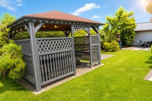 A gazebo with a lattice design, a tiled roof, and a surrounding lawn. - Studio for 4 people, close to the sea (Dziwnówek)
