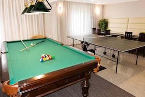 A pool table with balls, a ping pong table, and a seating area with chairs and a table. - Studio for 3 people, close to the sea (Dziwnówek)
