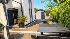 An outdoor patio area with picnic tables and potted plants. - Studio for 2 people, close to the sea (Dziwnówek)