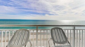 A balcony with two white chairs facing a beach and ocean view. - Carolinian Beach Resort 1731 (Myrtle Beach)