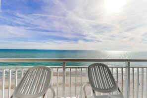 A balcony with two white chairs facing a beach and ocean view. - Carolinian Beach Resort 1731 (Myrtle Beach)