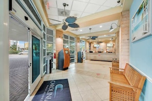 A hotel lobby with a reception desk, seating area, and a view of the street outside. - Carolinian Beach Resort 1731 (Myrtle Beach)
