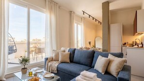 A modern living room with a sofa, a glass coffee table, and a view of the city. - ALL Gargasole | Luxury Sky-High Retreat with 2 Private Terraces (Bari)