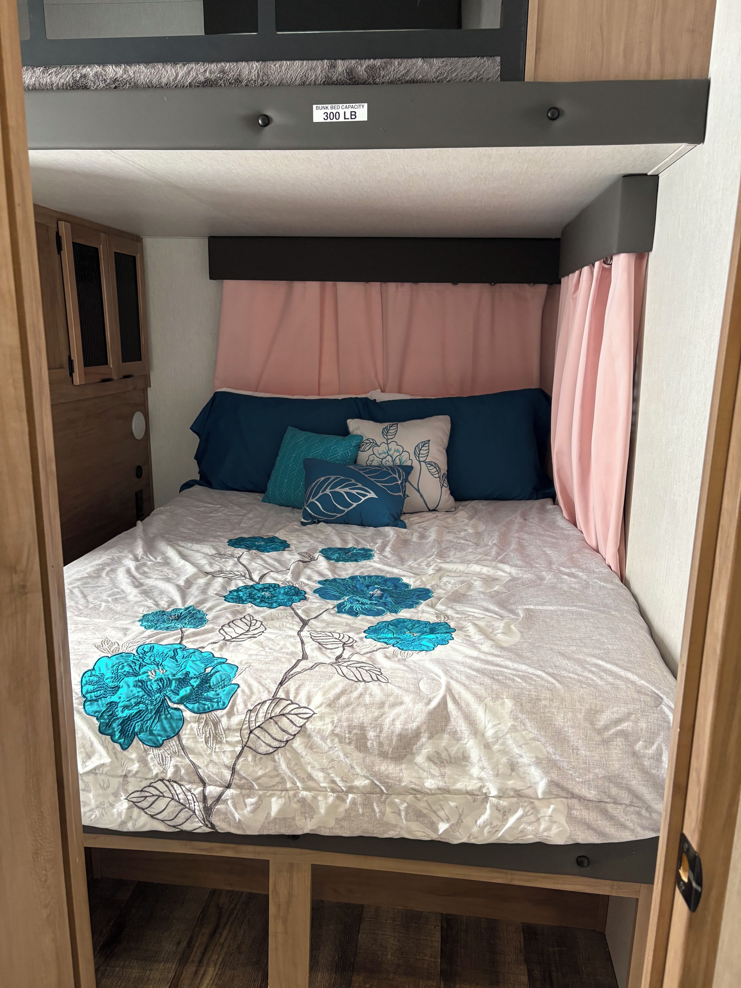 A bunk bed with a label indicating a bunk bed capacity of 300 lb.