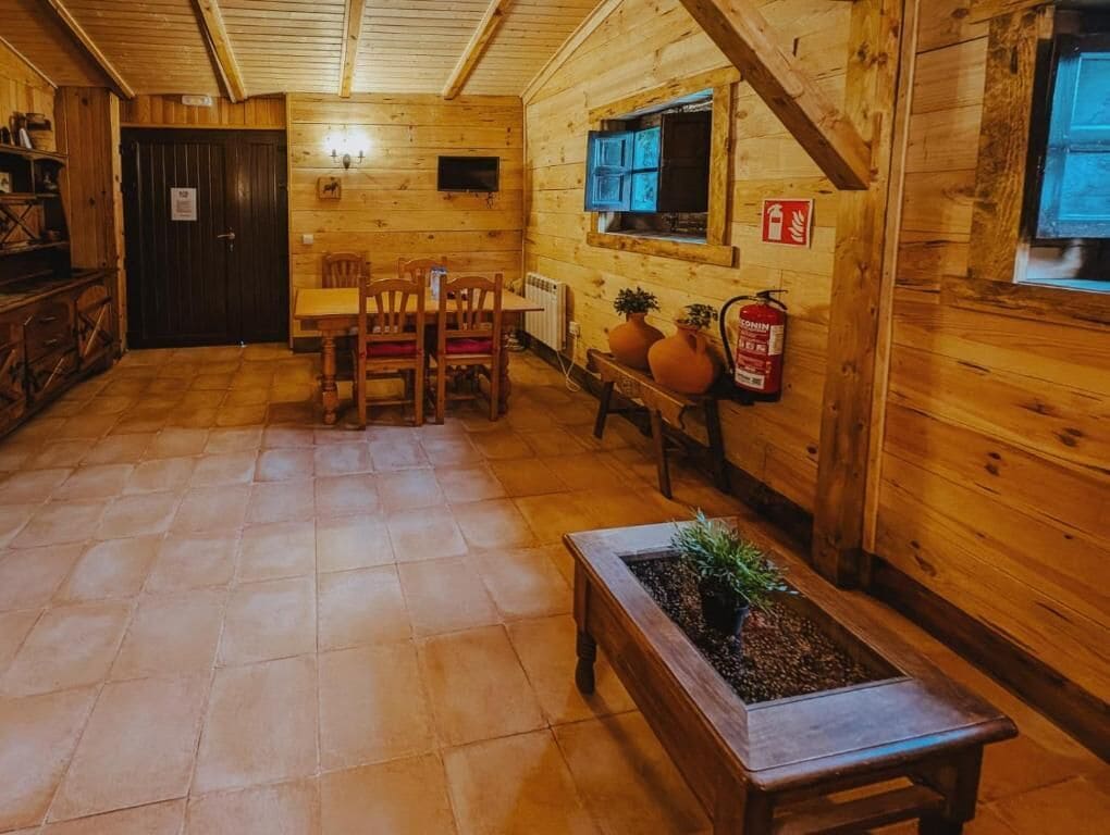 Un interior de madera con comedor, chimenea y extintor.