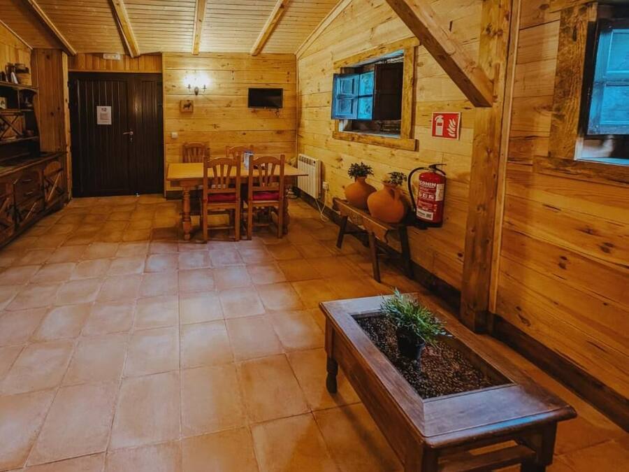 Un intérieur en bois comprenant un coin repas, une cheminée et un extincteur.