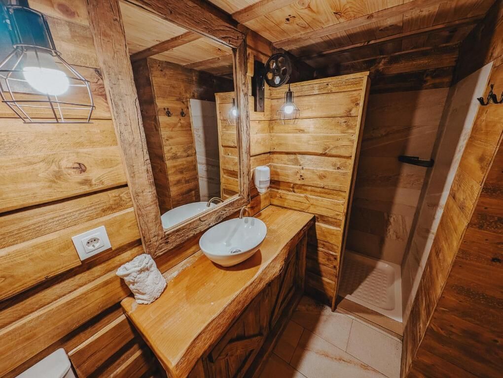 Un intérieur en bois comprenant un évier, un miroir et un luminaire.