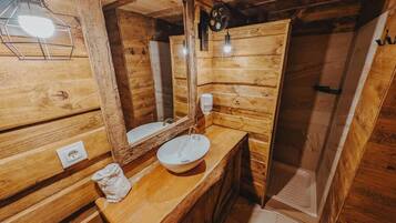 Un intérieur en bois comprenant un évier, un miroir et un luminaire.