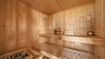 A wooden sauna with benches and a small table.
