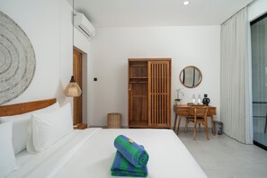 A hotel room with a bed, a desk, a wardrobe, and a bathroom.