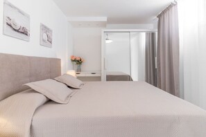 A hotel room with a bed, a desk with a lamp, and a sliding door leading to a bathroom. - Nice Bungalow with Two Bedrooms (Playa de la Américas)