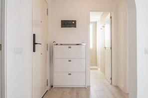 A narrow hallway with a white cabinet, a door, and a wall-mounted light fixture. - Nice Bungalow with Two Bedrooms (Playa de la Américas)