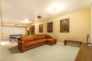 Ein Wohnzimmer mit Sofa, Couchtisch und Kunstwerken an den Wänden.