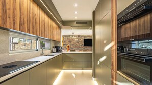 Una cocina moderna con salpicadero de piedra, electrodomésticos de acero inoxidable y muebles de madera.