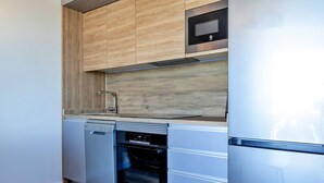 A compact kitchen with a dishwasher, oven, and a built-in microwave above the counter. - 1bedroom ocean view apartment (Costa Adeje)