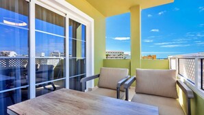 A balcony with a table and chairs, a view of buildings, and a clear sky. - 1bedroom ocean view apartment (Costa Adeje)