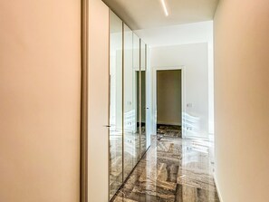 A corridor with a glass partition and a polished floor, leading to a room with a door. - La Maison del Borgo - Bergamo (Bergamo)