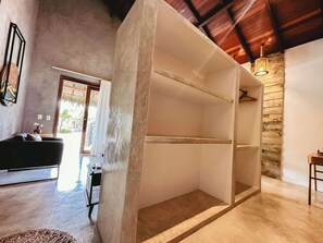 Un interior moderno con una pared de concreto, una lámpara colgante y vistas a través de un vidrio.