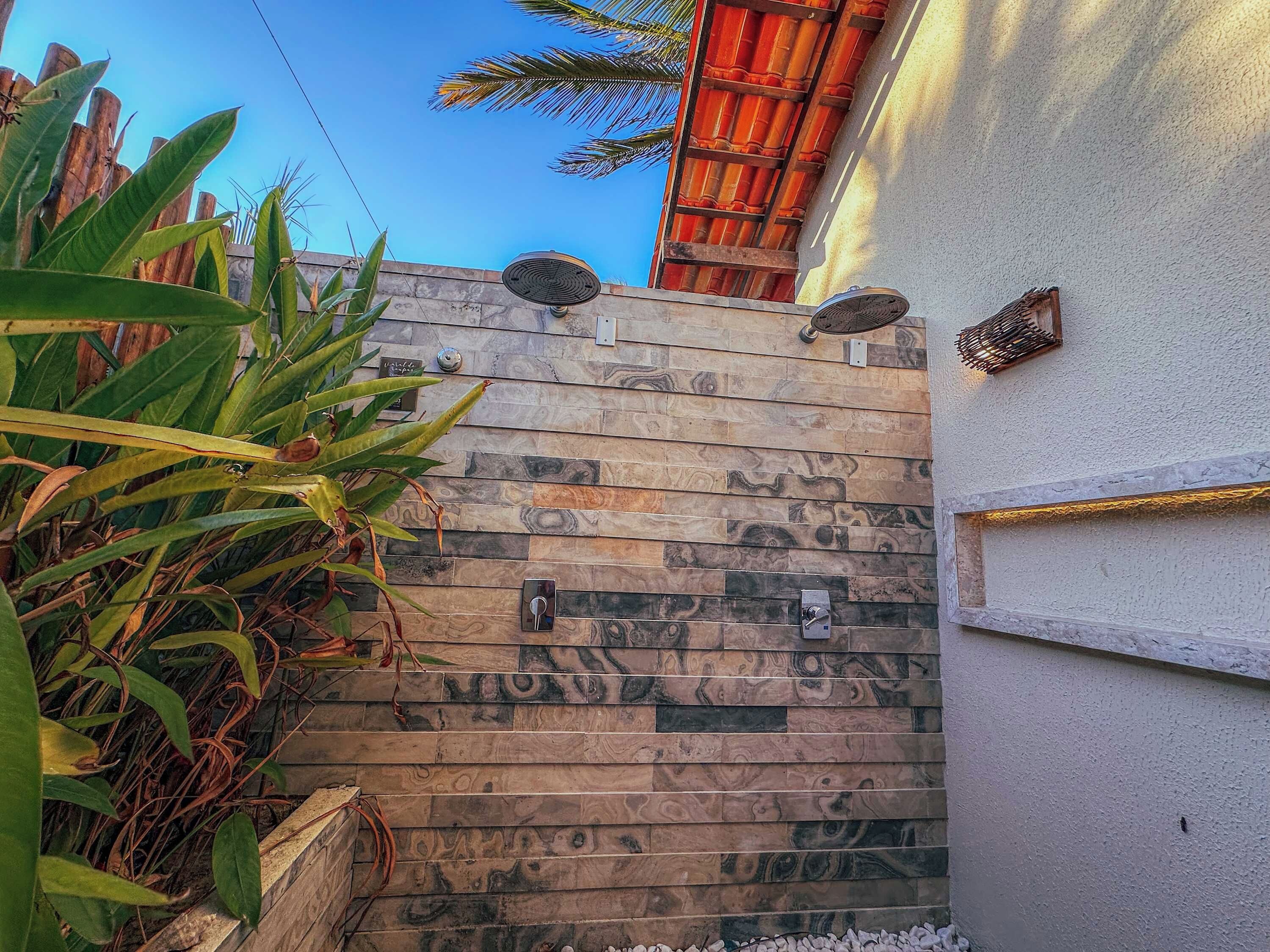 A textured wall with a mix of stone and wood patterns, a metal door with a handle, and a small metal plaque.