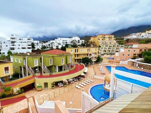 Ein Resort mit mehreren Gebäuden, einem Poolbereich und einer Bergkulisse.
