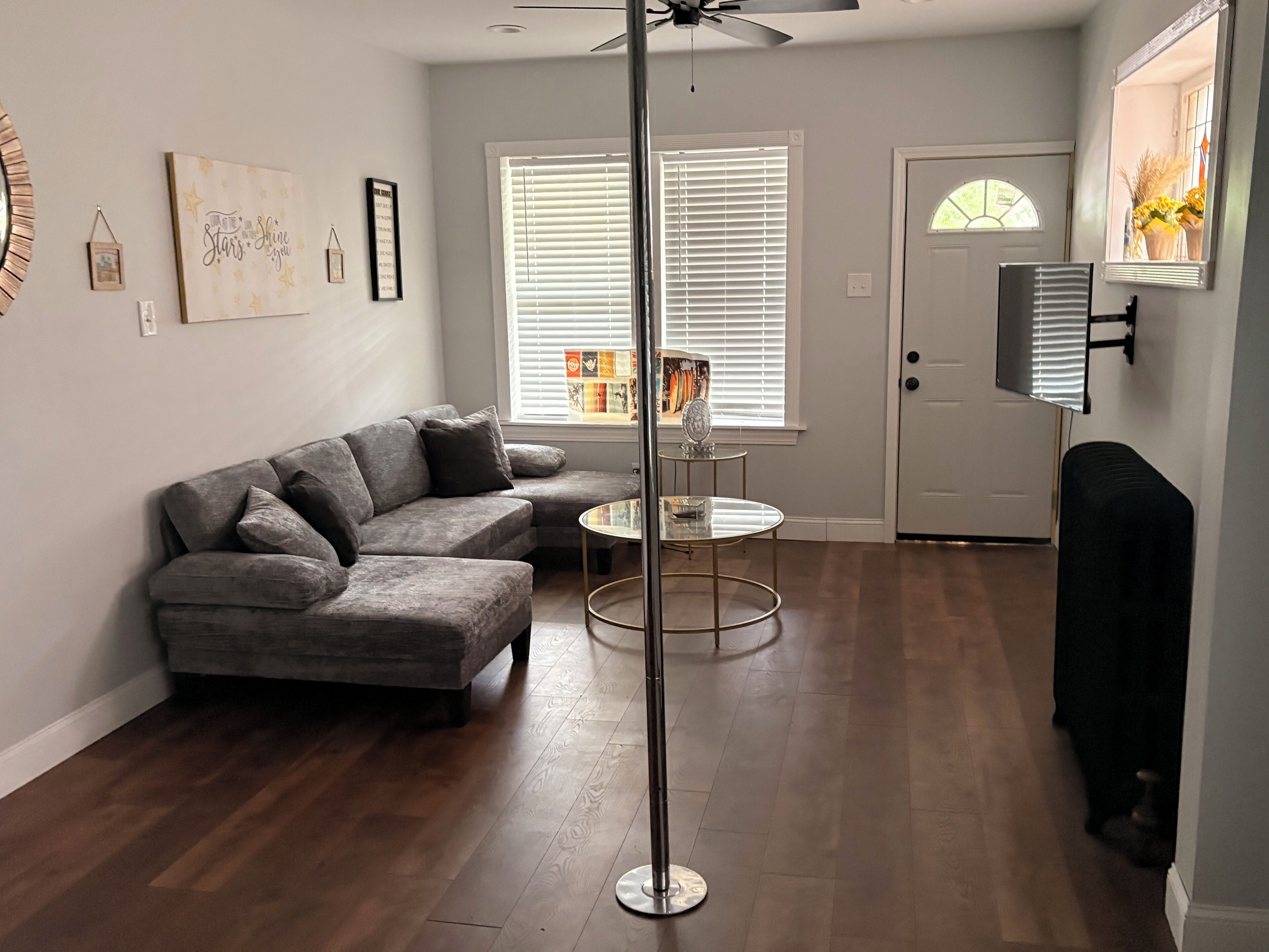 A living room with a grey sectional sofa, a round coffee table, and a floor lamp.