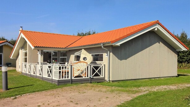 Ein eingeschossiges Gebäude mit rotem Ziegeldach, einer überdachten Terrasse und der Hausnummer 134.