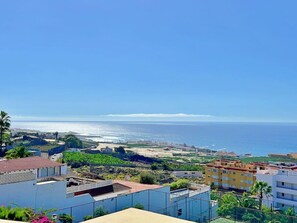 Ein Küstenwohngebiet mit Gebäuden, einem Strand und blauem Himmel.