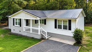 A single-story house with a front porch, a garage, and a small front yard.
