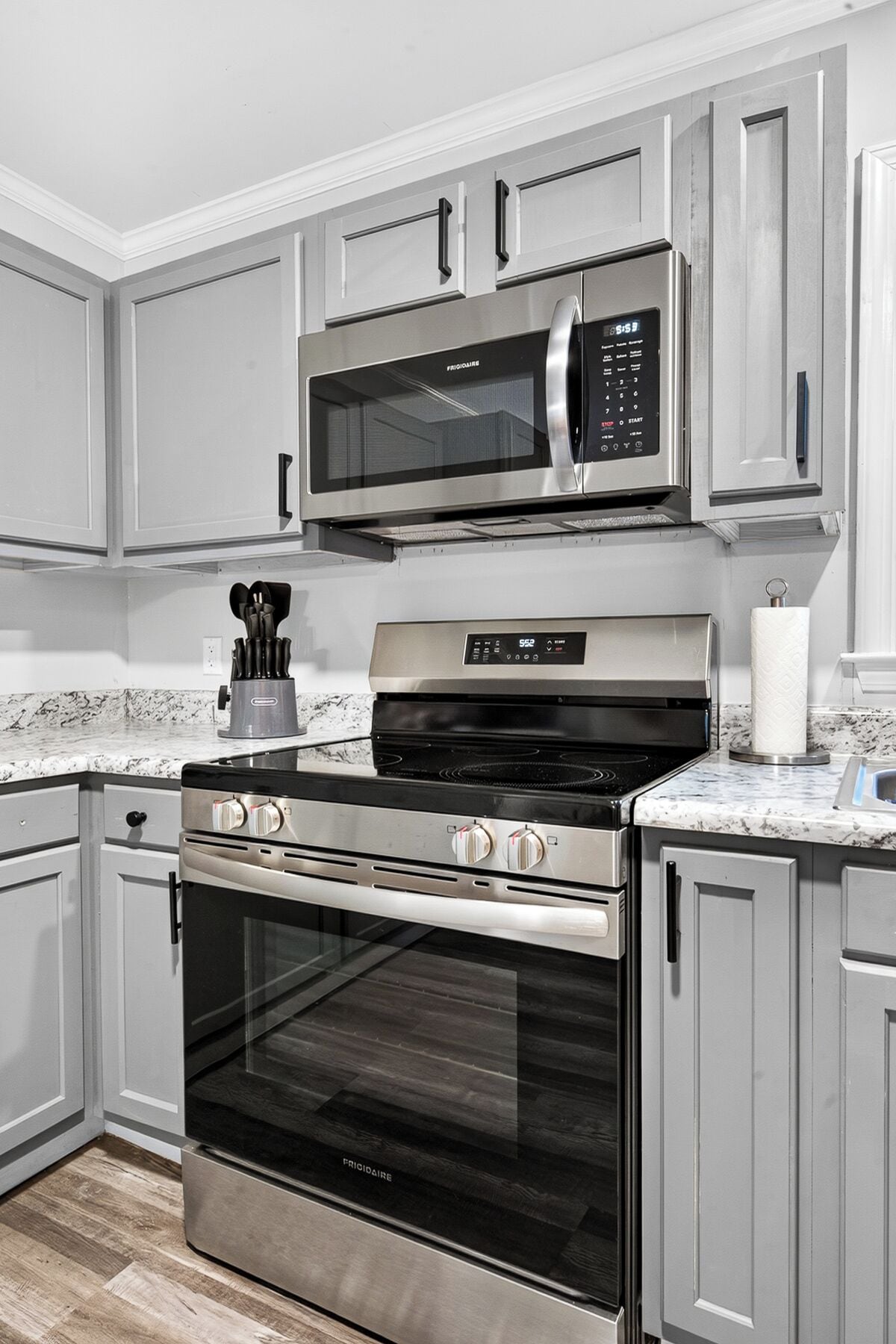 A kitchen with stainless steel appliances, including a microwave, oven, and stovetop.