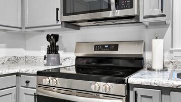 A kitchen with stainless steel appliances, including a microwave, oven, and stovetop.