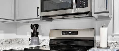 A kitchen with stainless steel appliances, including a microwave, oven, and stovetop.