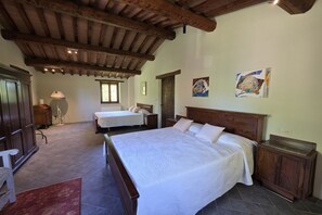 A bedroom with two beds, wooden headboards, a large window, and artwork on the walls. - Villa Tufi by MMega (Montone)