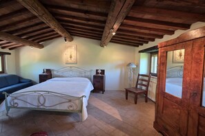 Een slaapkamer met een bed, nachtkastjes, een stoel en een kledingkast.