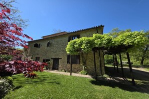 A stone building with a garden and a pergola. - Villa Tufi by MMega (Montone)
