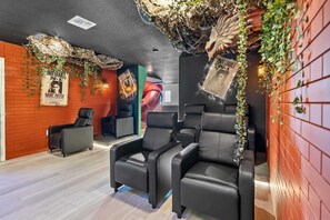 Ein Zimmer mit schwarzen Ledersesseln, einer roten Backsteinwand und Harry-Potter-Postern.